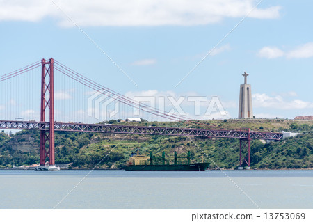 A cargo ship going under the suspension bridge A cargo ship going under the suspension bridge 13753069