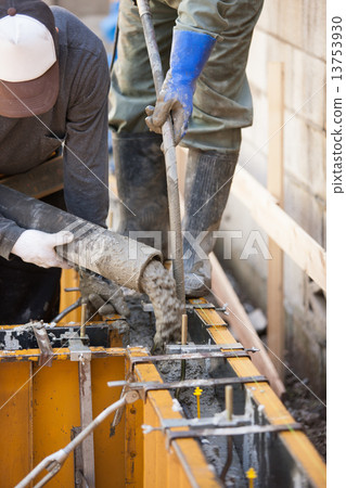 Concrete placing on raw foundation construction frame of housing 13753930