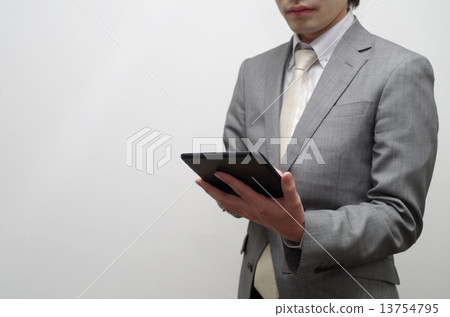 Businessman fiddling tablet 13754795