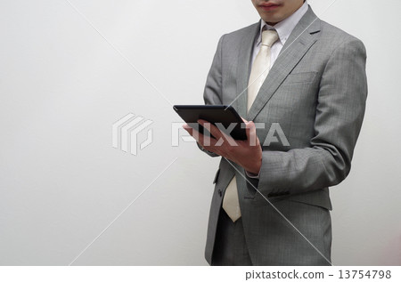 Businessman fiddling tablet 13754798