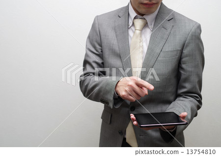 A businessman fiddling with a tablet A businessman fiddling with a tablet 13754810