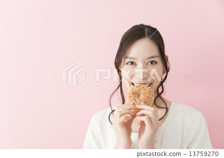 A young woman eating a donut 13759270