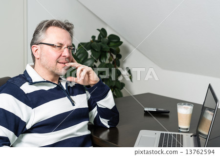 Man working from home on laptop computer 13762594