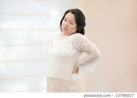 一名中年婦女在休閒服，站在室內 13766837