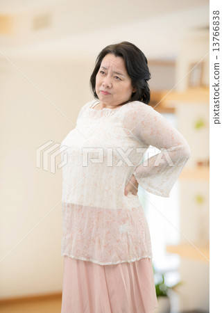 A middle-aged woman in casual wear, standing indoors 13766838