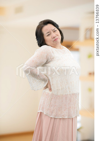 A middle-aged woman in casual wear, standing indoors 13766839