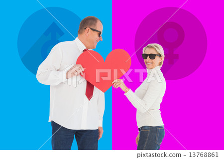 Composite image of older affectionate couple holding red heart s 13768861