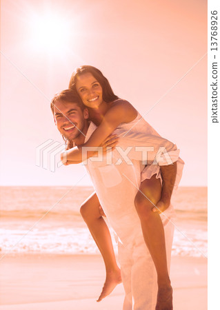 Smiling man giving happy girlfriend a piggy back Smiling man giving happy girlfriend a piggy back 13768926