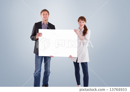 Composite image of smiling couple holding large sign Composite image of smiling couple holding large sign 13768933