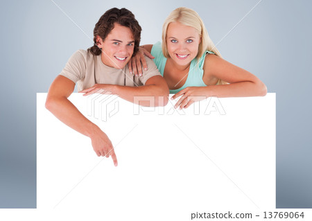 Composite image of handsome man pointing on a whiteboard with wo 13769064