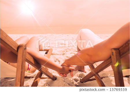 Couple resting on deck chairs 13769339