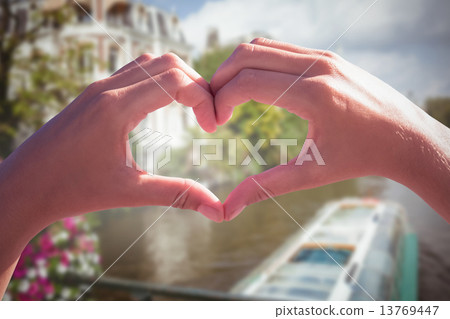 Composite image of hands making heart shape on the beach 13769447