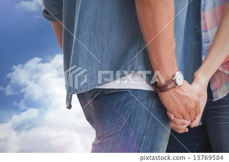 Composite image of hip young couple holding hands Composite image of hip young couple holding hands 13769584