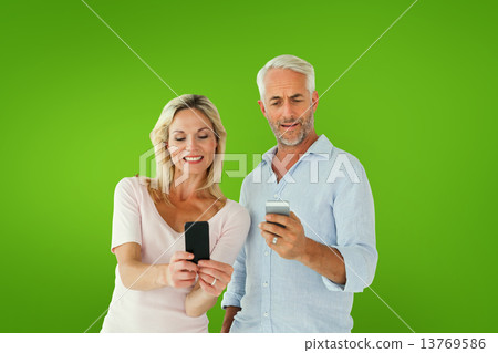 Composite image of happy couple texting on their smartphones Composite image of happy couple texting on their smartphones 13769586