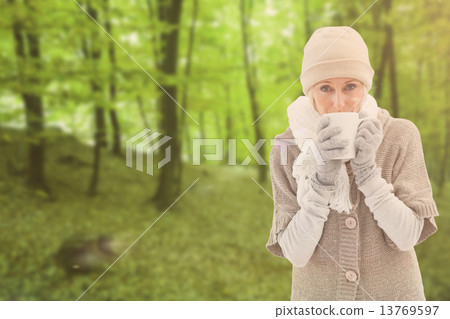 Composite image of woman in warm clothing holding mugs Composite image of woman in warm clothing holding mugs 13769597