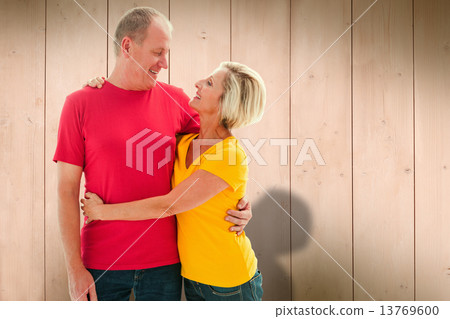 Composite image of happy mature couple hugging and smiling Composite image of happy mature couple hugging and smiling 13769600