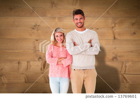 Composite image of attractive couple smiling with arms crossed 13769601