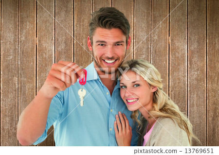 Composite image of attractive young couple showing new house key 13769651