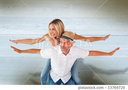 Composite image of happy man giving his partner a piggy back Composite image of happy man giving his partner a piggy back 13769720