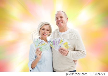 Composite image of happy mature couple smiling at camera showing Composite image of happy mature couple smiling at camera showing 13769721