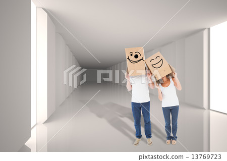 Composite image of mature couple wearing boxes over their heads 13769723