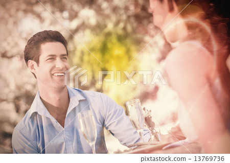 Couple with champagne flutes sitting at an outdoor cafÃ
 Couple with champagne flutes sitting at an outdoor cafÃ
 13769736