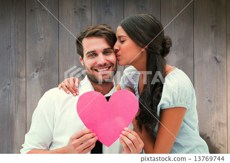 Composite image of pretty brunette giving boyfriend a kiss and h 13769744