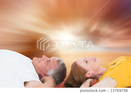Composite image of casual couple lying on floor Composite image of casual couple lying on floor 13769796