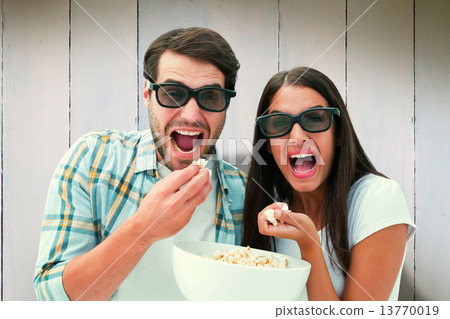 Composite image of attractive young couple watching a 3d movie 13770019