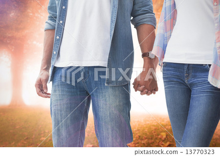 Composite image of hip young couple holding hands 13770323
