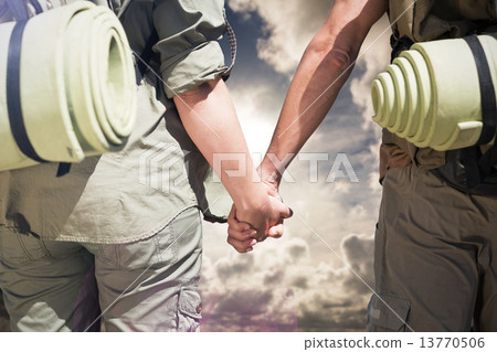Composite image of hitch hiking couple standing holding hands on 13770506