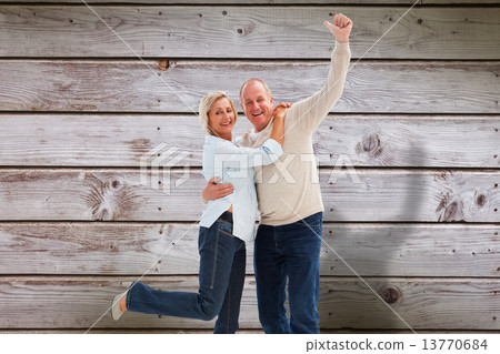 Composite image of happy mature couple cheering at camera Composite image of happy mature couple cheering at camera 13770684