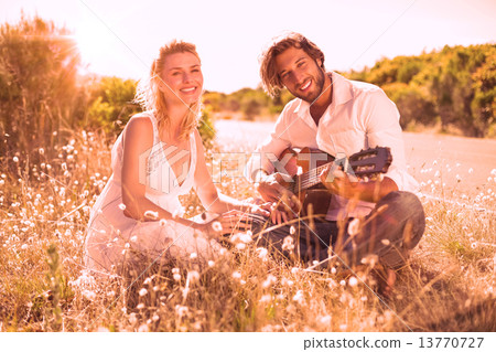 Handsome man serenading his girlfriend with guitar Handsome man serenading his girlfriend with guitar 13770727