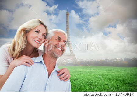 Composite image of smiling couple embracing and looking 13770917