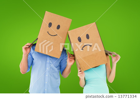 Composite image of couple wearing sad face boxes on their heads Composite image of couple wearing sad face boxes on their heads 13771334