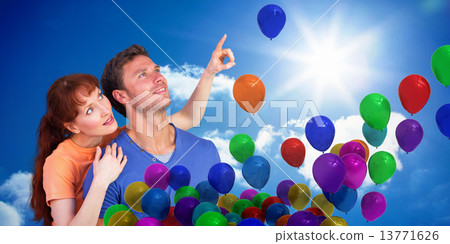 Composite image of happy couple looking upwards 13771626