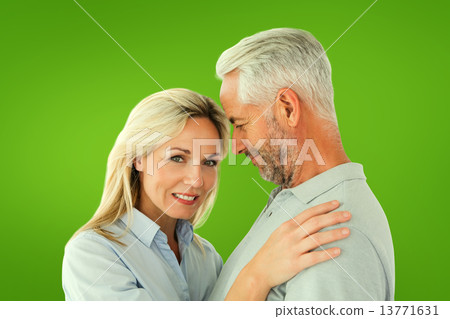 Composite image of happy couple standing and smiling at camera 13771631