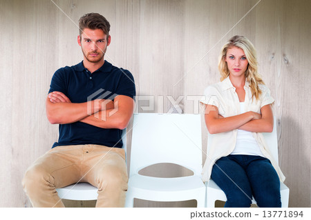 Composite image of young couple sitting in chairs not talking du Composite image of young couple sitting in chairs not talking du 13771894
