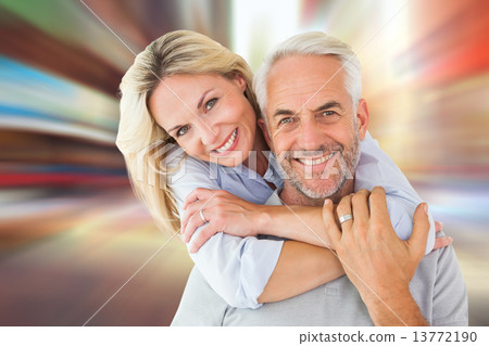 Composite image of happy couple standing and hugging 13772190