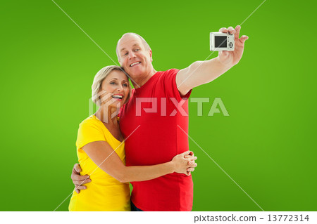Composite image of happy mature couple taking a selfie together Composite image of happy mature couple taking a selfie together 13772314