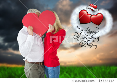 Composite image of couple embracing and holding heart over faces 13772542