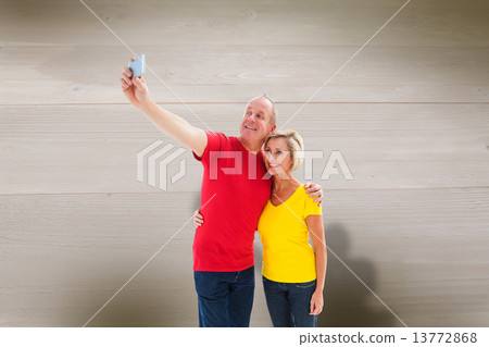 Composite image of happy mature couple taking a selfie together Composite image of happy mature couple taking a selfie together 13772868