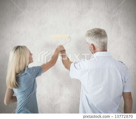 Composite image of happy couple painting wall with roller Composite image of happy couple painting wall with roller 13772870
