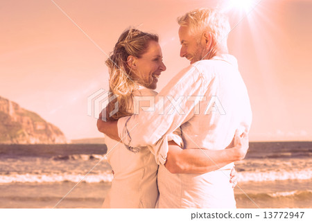 Happy couple on the beach smiling at each other 13772947
