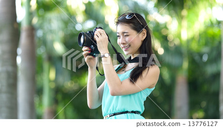 One young Chinese woman taking picture with DSLR One young Chinese woman taking picture with DSLR 13776127
