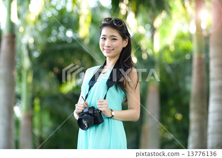 One young Chinese woman taking picture with DSLR  13776136