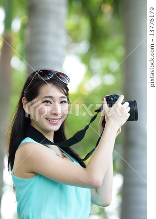One young Chinese woman taking picture with DSLR  13776179