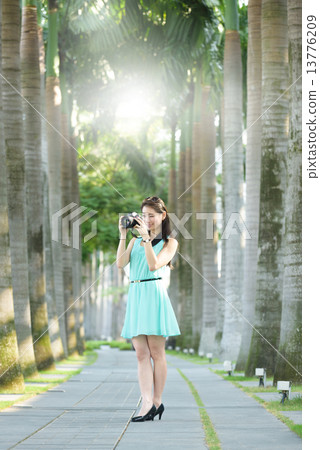 One young Chinese woman taking picture with DSLR  13776209