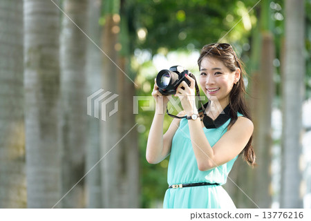 One young Chinese woman taking picture with DSLR One young Chinese woman taking picture with DSLR 13776216
