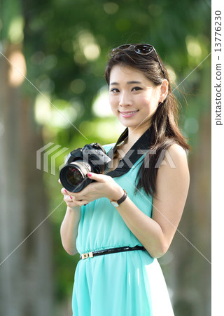 One young Chinese woman taking picture with DSLR  13776230